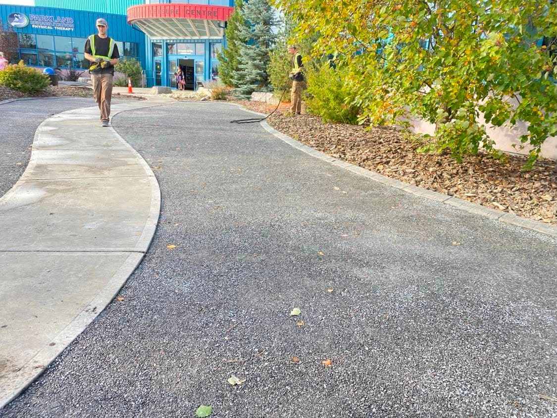 A finished commercial walkway bordered by fresh mulch beds and autumn planting
